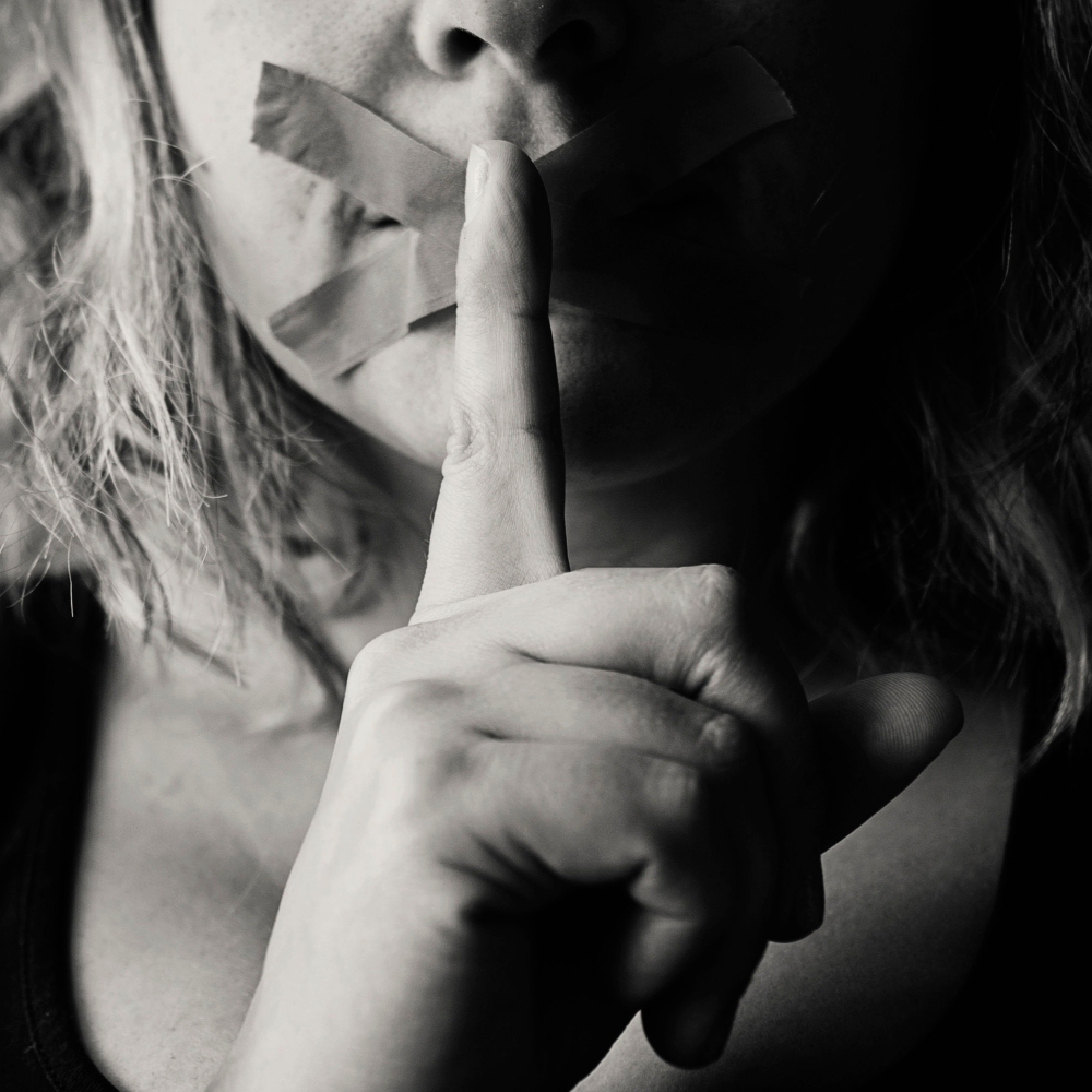 black and white photo of a women with her finger to her lips