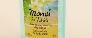 A 150 ml (5 fl. oz) bottle of Lagoon Hair and Body Wash is displayed, adorned with a label that captures a tropical beach scene and a white flower, embodying the essence of Monoi de Tahitis serene allure.