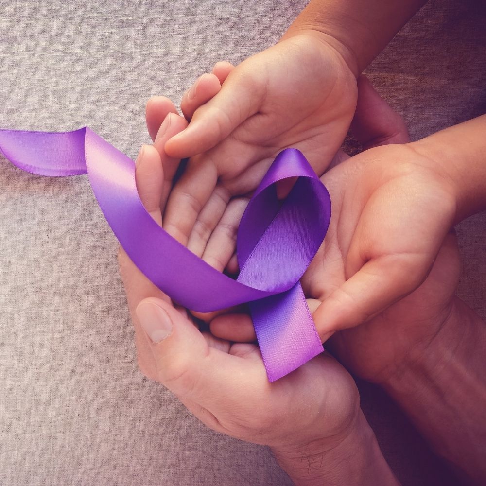 child and adult holding a purple ribbon which can be used for domestic violence awareness 