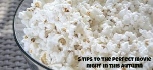 A glass bowl filled with popcorn, placed on a woven surface. In the bottom right corner, text reads, 5 Tips to the Perfect Movie Night in This Autumn.