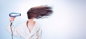 Lady with hair blowing in a hairdryer