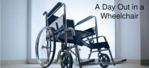 A wheelchair is positioned indoors facing a large, bright window, with the text A Day Out in a Wheelchair in the upper right corner.