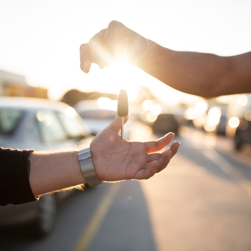 person handing over car keys