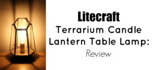 Litecraft Terrarium Candle Lantern Table Lamp - Antique Brass with edison screw filament squirrel cage light bulb. Lamp lit up in semi darkness, picture taken from the front of the lamp