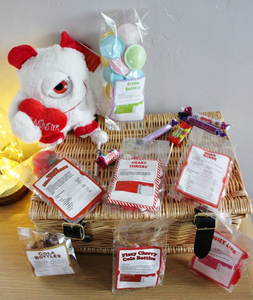 MenKind PERSONALISED SWEET HAMPER WITH CUDDLY TOY MONSTER. Monster sat on top of the hamper alongside some of the packets of sweets.