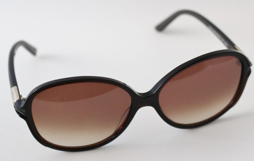 WILLIAM MORRIS ROUNDED SUNGLASSES view of glasses from slighlty above, the arm has a gold detail to just before the glasses start, the glasses are brown in colour