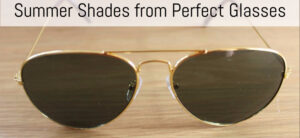Gold-rimmed aviator sunglasses with dark lenses on a wooden surface. Text at the top reads, Summer Shades from Perfect Glasses.