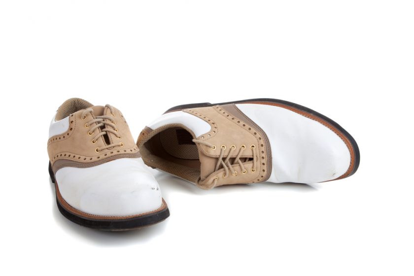A pair of golf shoes on a white background with copy space