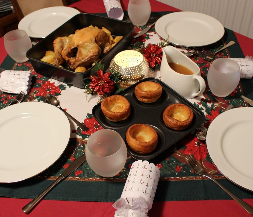Debenhams at Christmas - Christmas dinner table featuring yorkshire puddings, chicken, gravy, Photo also shows plates, crackers and glasses, taken from left hand side near yorkshire puddings.