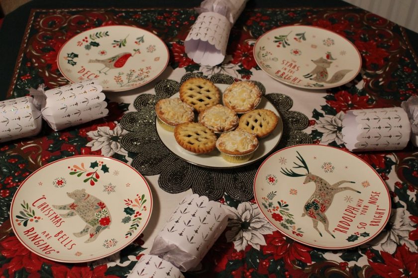Christmas at Debenhams, selection of small multicoloured Christmas plates featuring animals; robin, bear, fox and reindeer places with crackers and mince pies