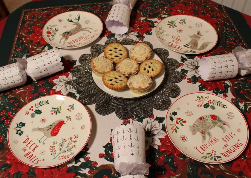Christmas at Debenhams, selection of small multicoloured Christmas plates featuring animals; robin, bear, fox and reindeer places with crackers and mince pies