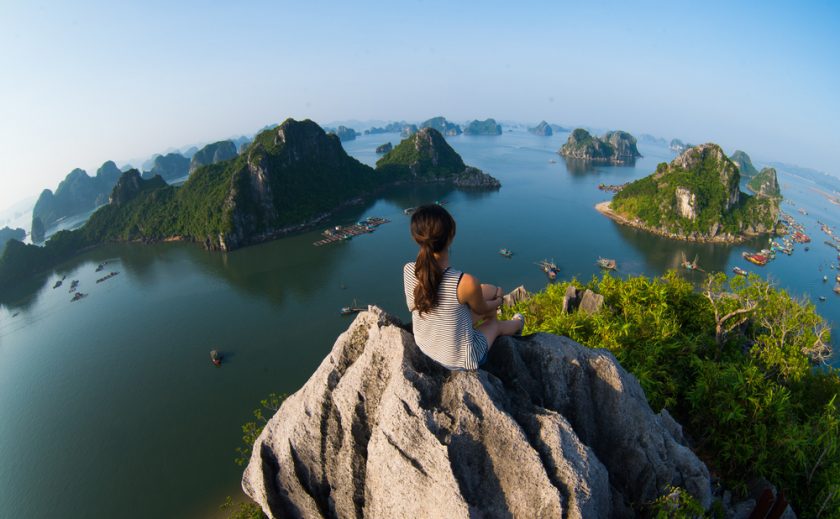 Lady sat on a rock over looking a beautiful sea view