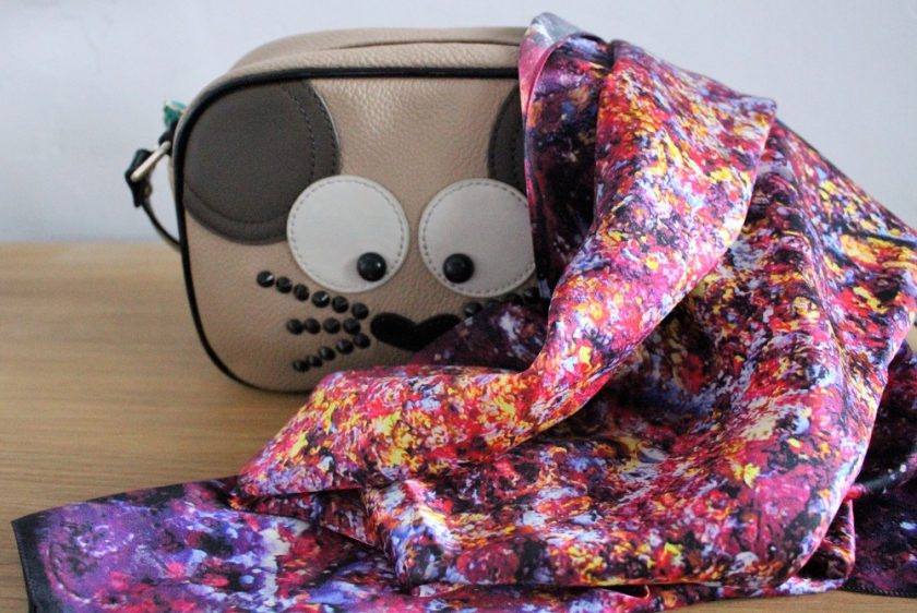 Aithne Vibrations of Carmine Scarf draped over the side of a handbag
