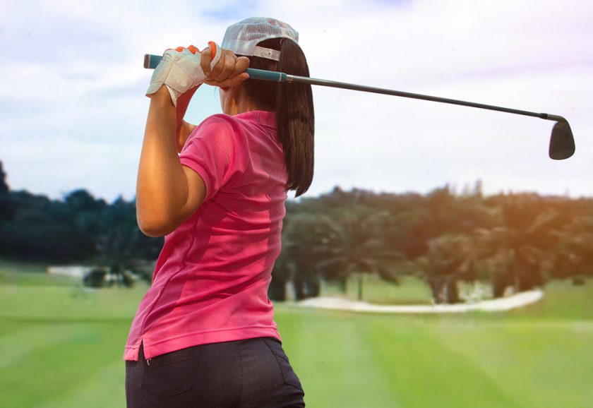 lady in pink tshirt playing golf