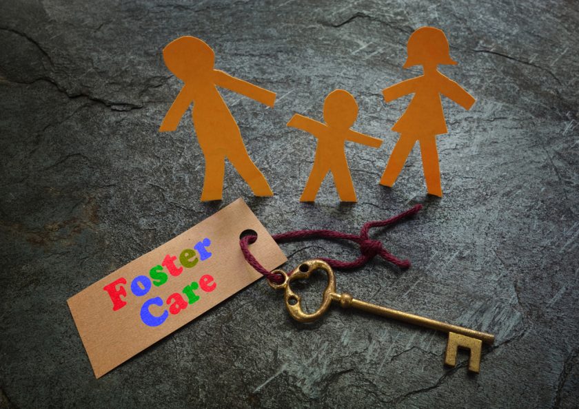 Paper foster care family of three with gold key
