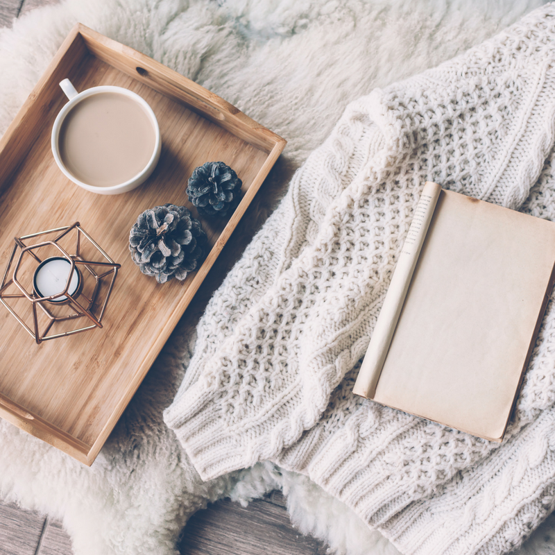 Tray with a drink and candle sat on a bed