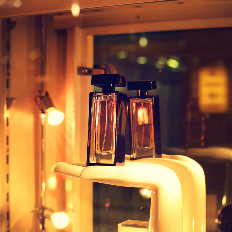 Perfume on display surrounded by lights.