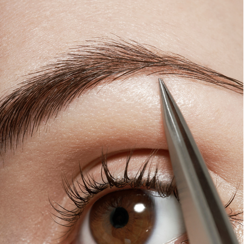 Lady plucking her eyebrows