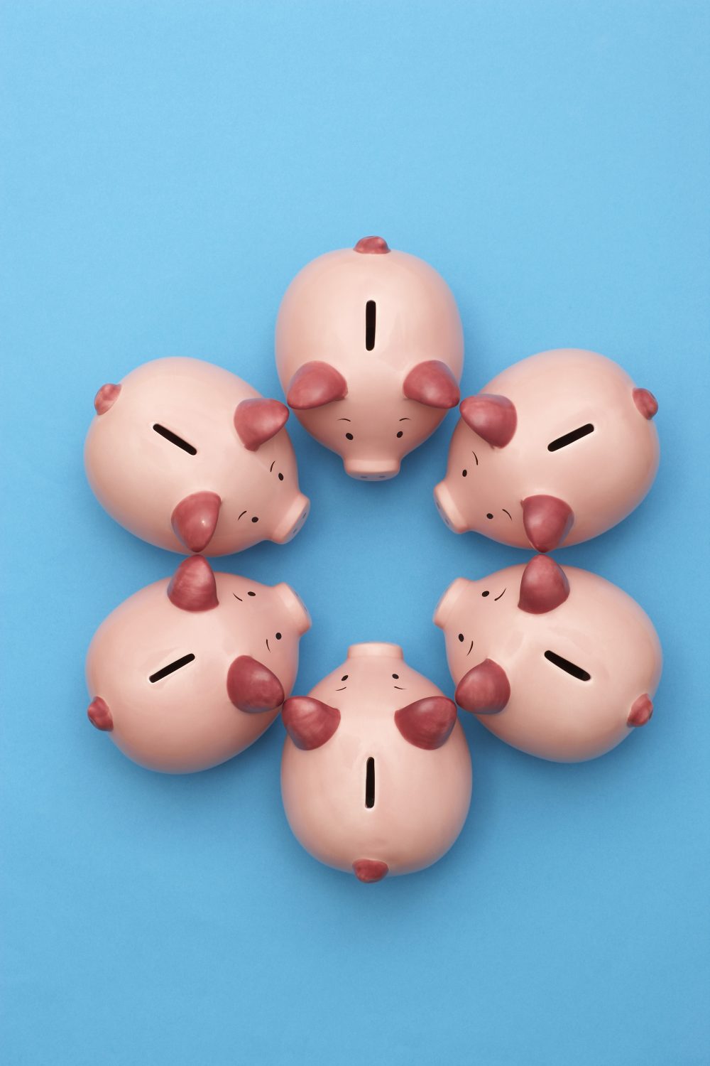 Piggy banks on blue background, view from above
