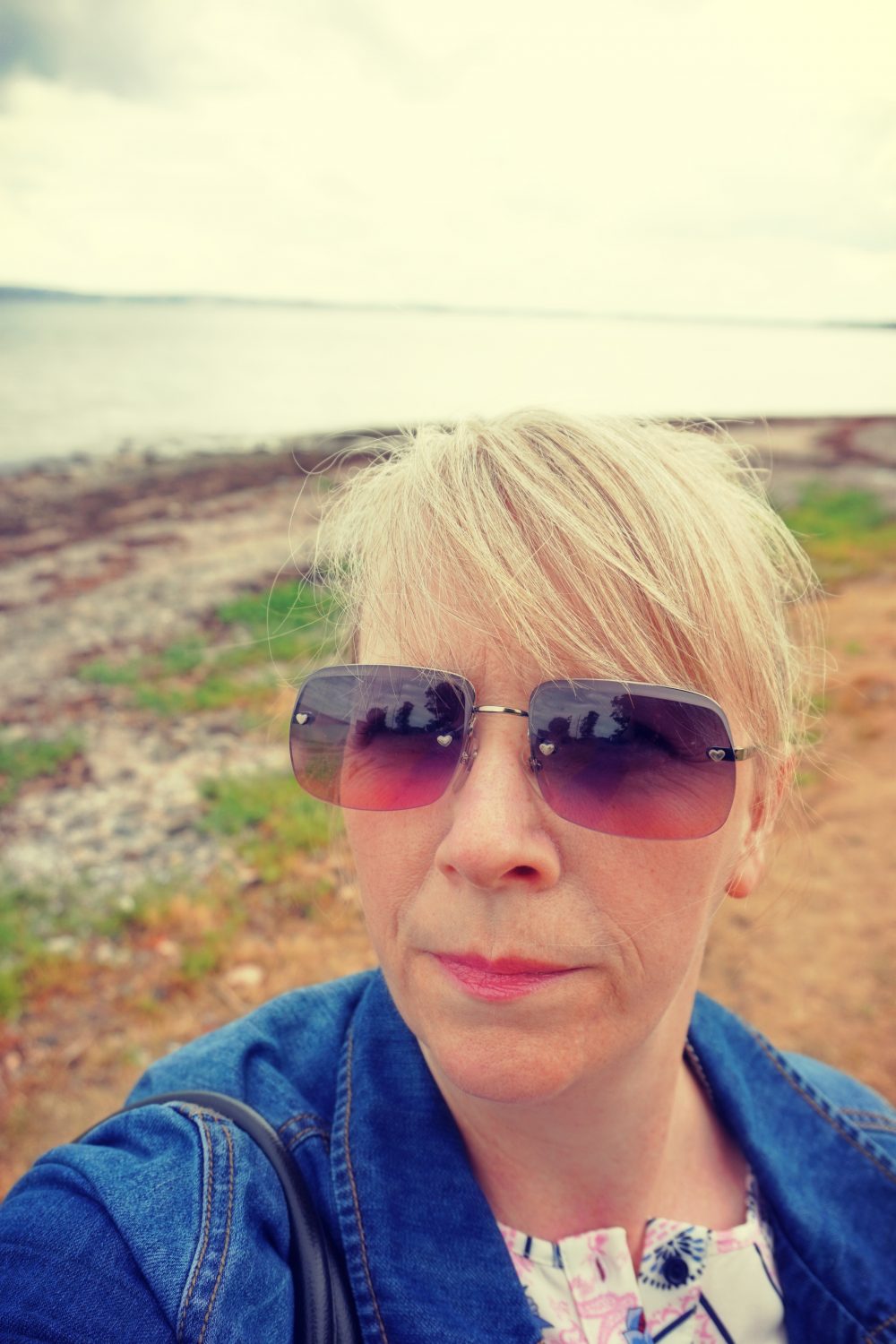 Photograph of Ellen, wearing sunglasses, beautiful view in the background