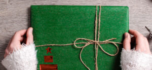person holding a green wrapped present