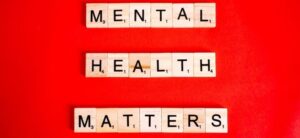 mental health matters written using scrabble tiles on a red backdrop