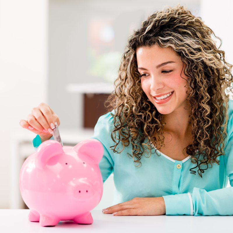 Lady putting a coin into a piggy bank
