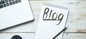 blog written on a note pad and laptop