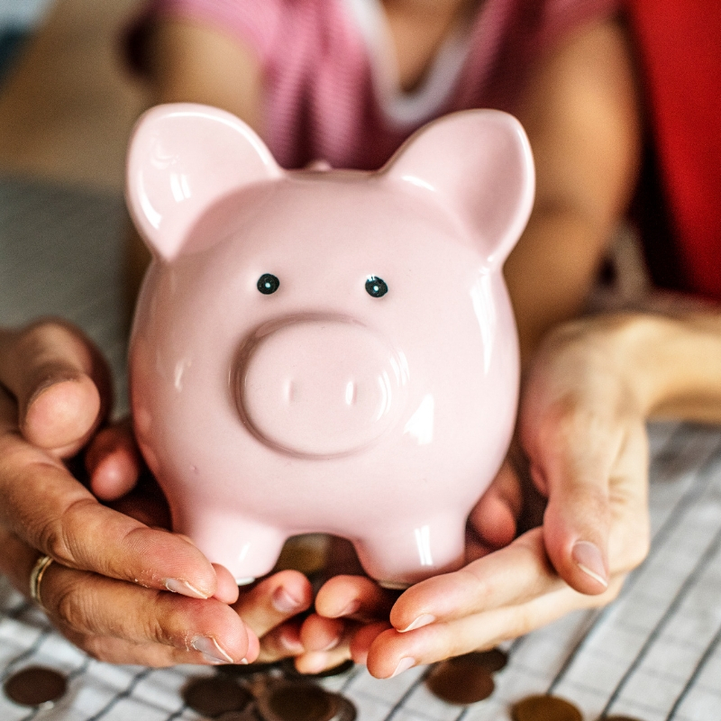 people holding onto a piggy bank