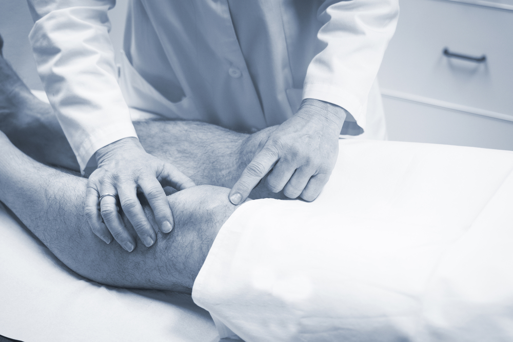 a doctor looking at a patients knee