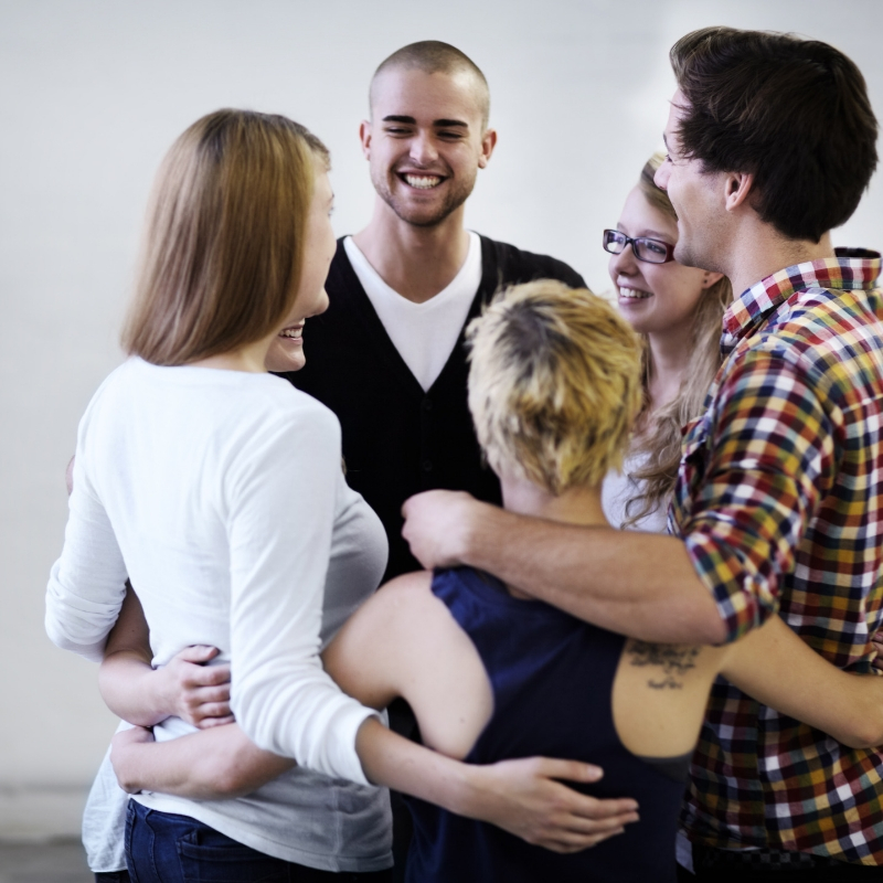 people standing in a circle with arms around each other