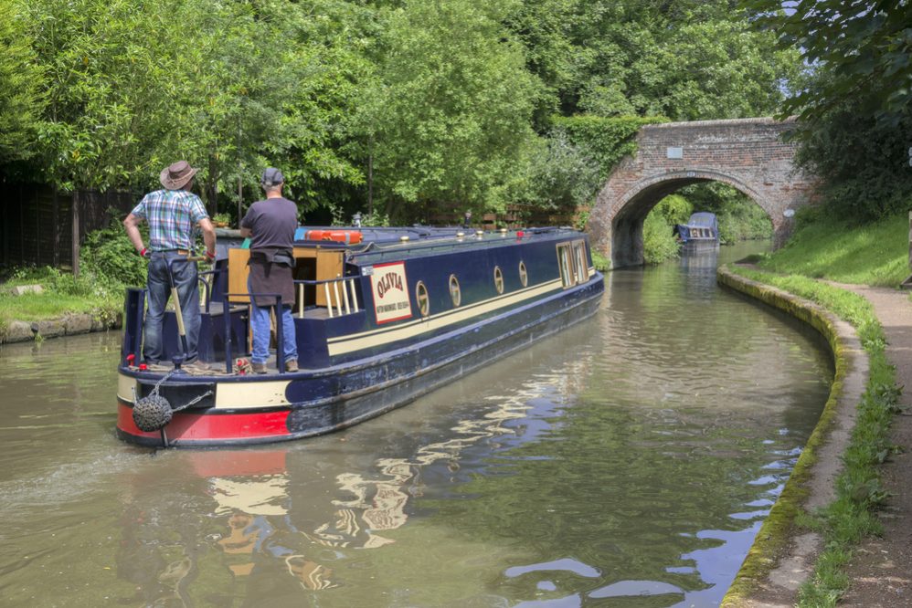 a narrow boat or barge on the grand union canal - the location is hatton flight of locks near leamington spa in warwickshire, the midlands, england, uk