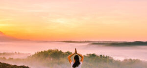 person practising yoga in front of a beautiful sky
