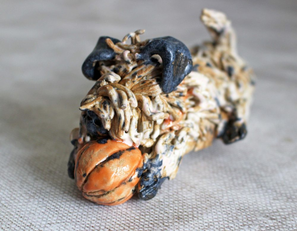 Pottery Dog with an Orange Ball