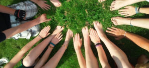 people with their hands out on the grass as a community