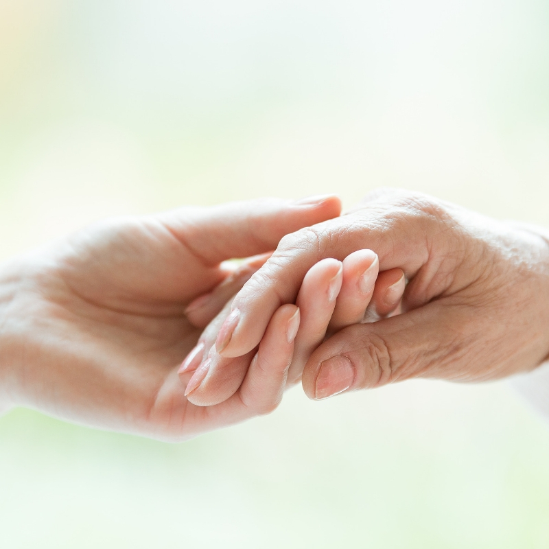 younger and older person holding hands