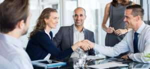 people sat in a business meeting two people shaking hands