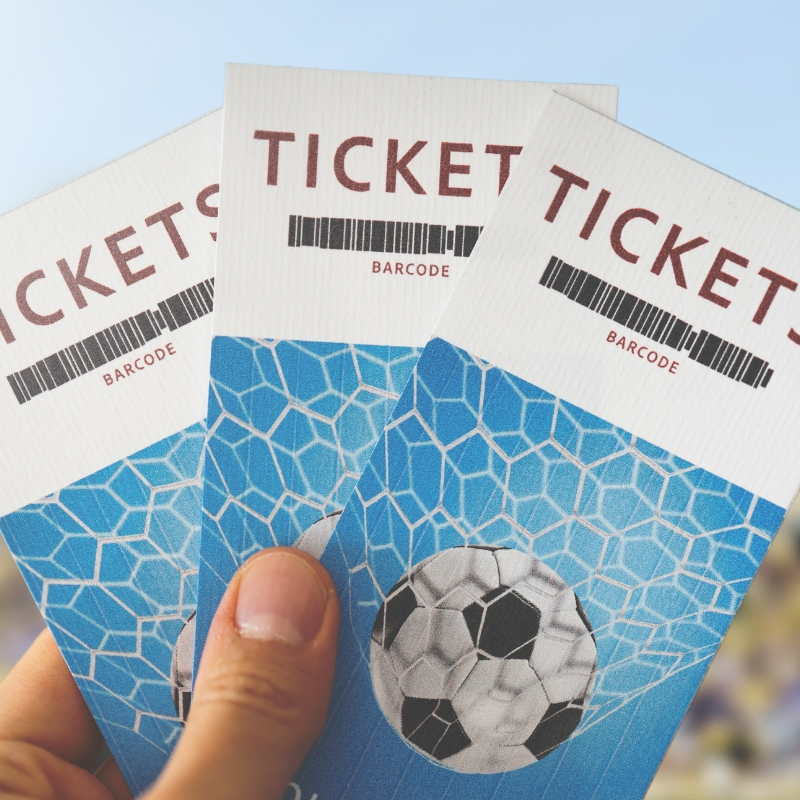 person holding tickets with a football on