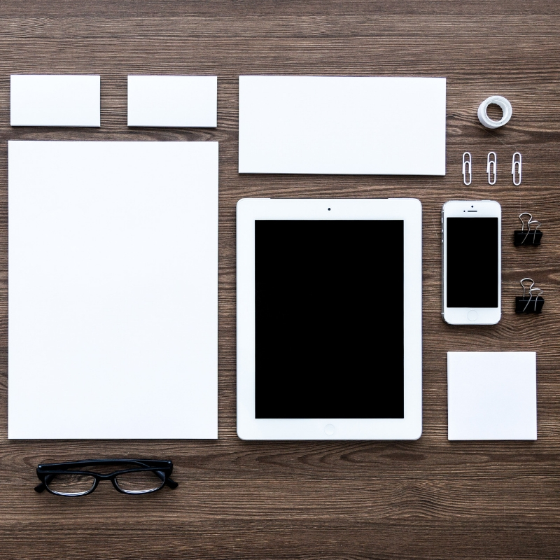 work space with phone, paper, ipad, glasses and stationery