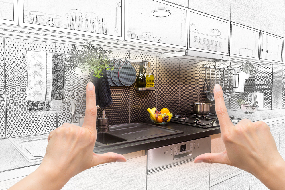 Female hands framing custom kitchen design. Combination drawing and photo.