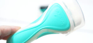 A close-up showcases a hand holding the Wilkinson Sword Intuition Sensitive Care razor in teal and white, featuring a built-in shaving soap head. The word Intuition is embossed on the handle against a softly blurred white background.
