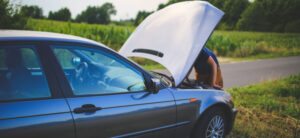 car with hood up on a road