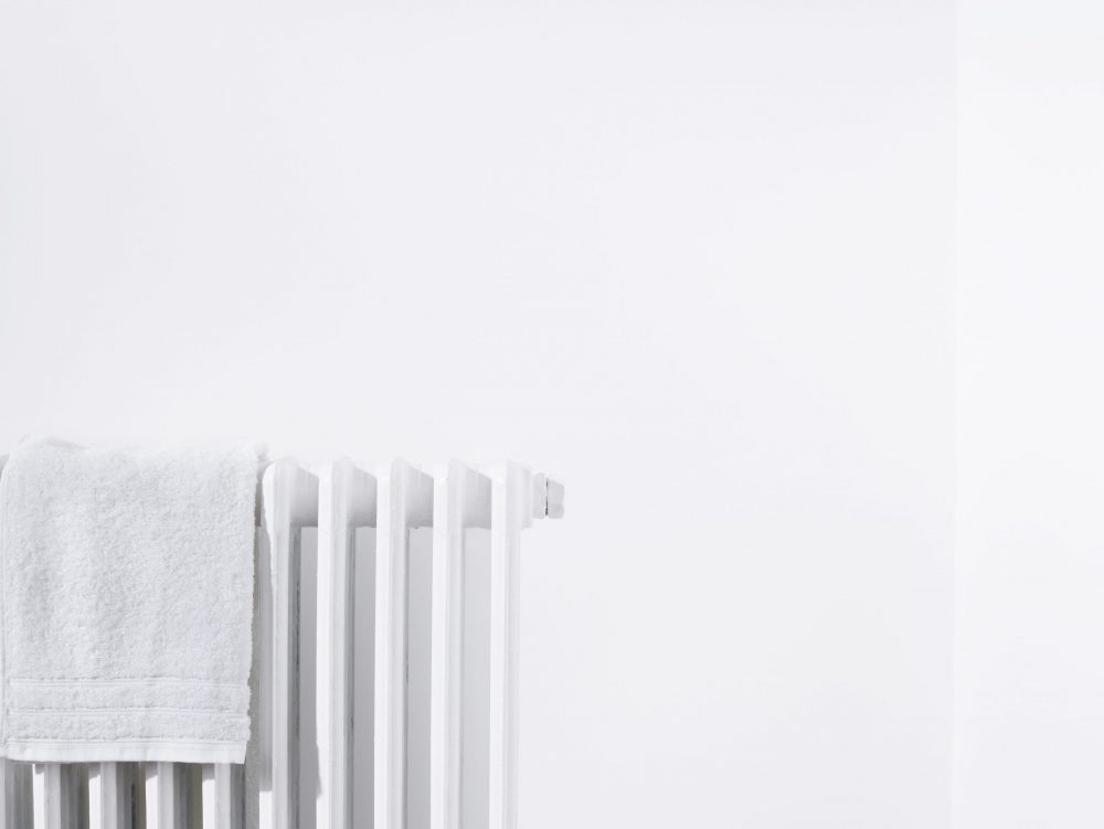 Towel on radiator and white wall