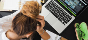 lady with her head in her hands on her laptop