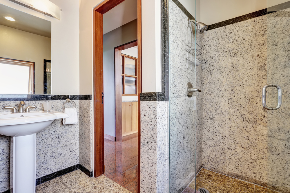 Modern marble bathroom with walk-in shower and washbasin stand with mirror. House interior. Northwest, USA