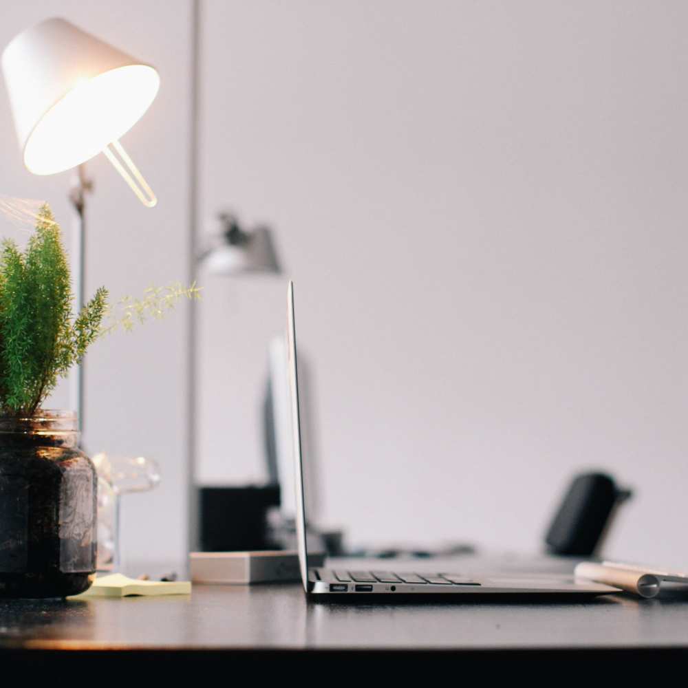 desk with lamp and laptop on it.