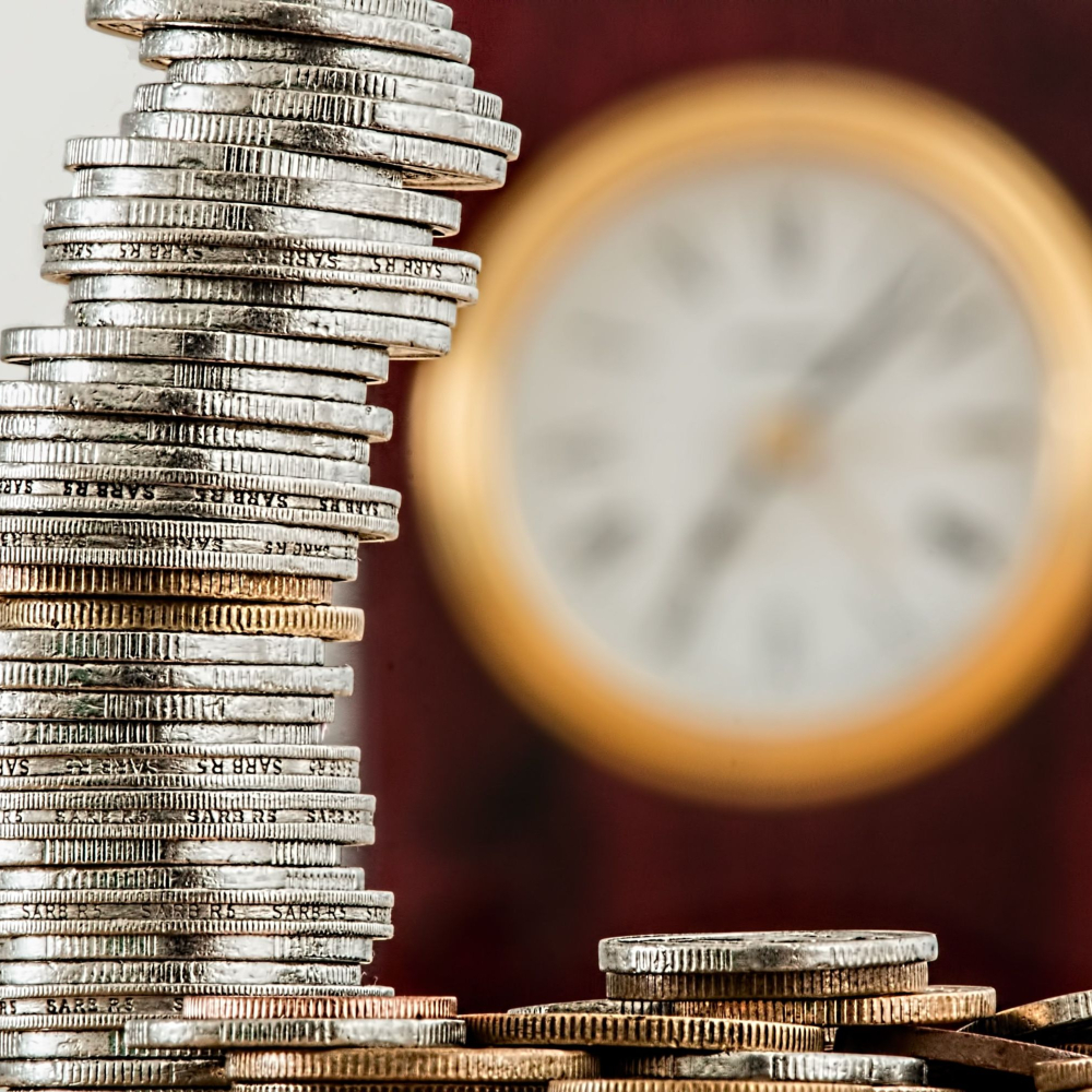 coins stacked with a clock behind