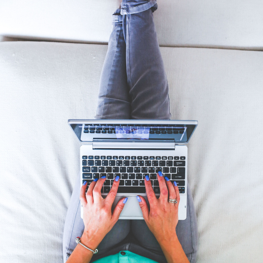 person working on their bed on their computer