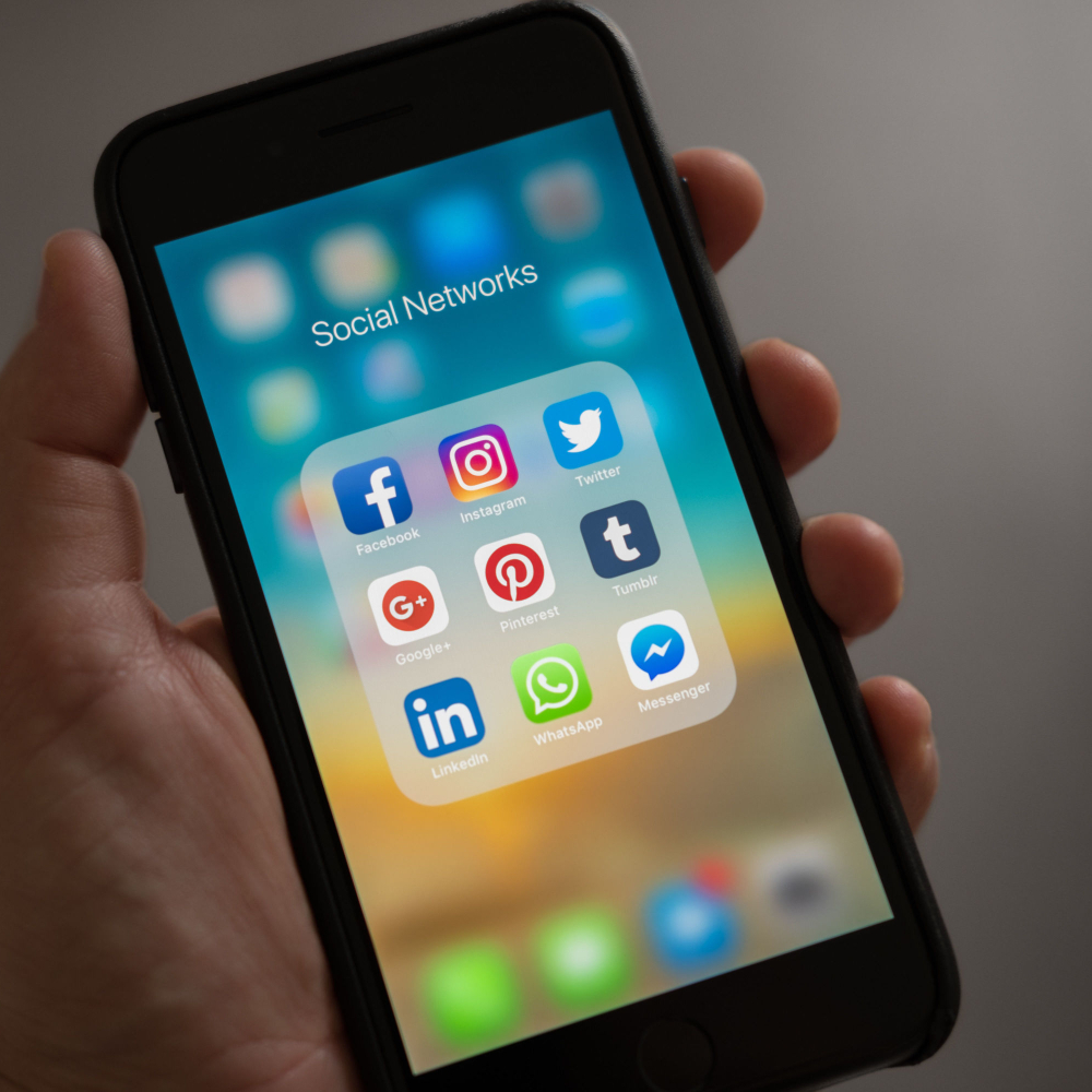 someone holding a mobile with social networks showing