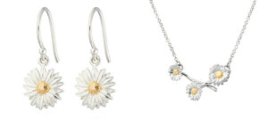Silver jewelry set featuring daisy designs: a pair of dangling earrings with daisy pendants and a necklace with three daisy charms on a branch. The daisies have detailed silver petals and gold centers.